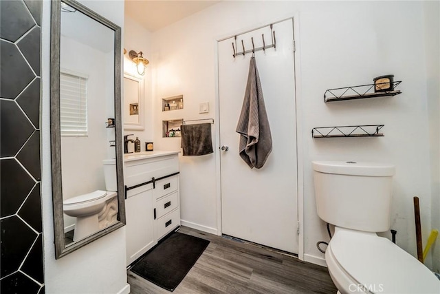 bathroom with hardwood / wood-style flooring, vanity, and toilet