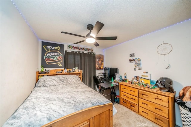 carpeted bedroom featuring ceiling fan and a textured ceiling