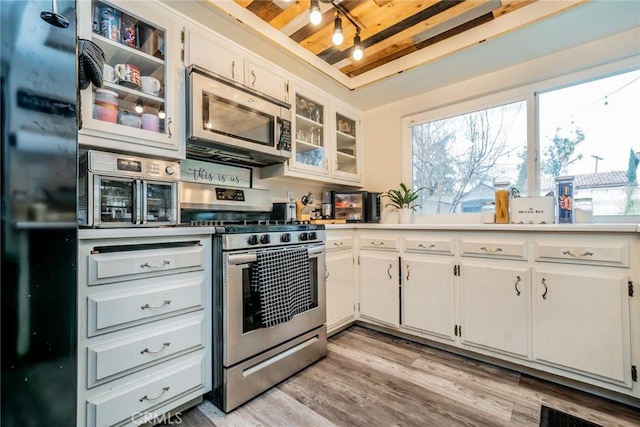 kitchen with appliances with stainless steel finishes, light hardwood / wood-style floors, and white cabinets