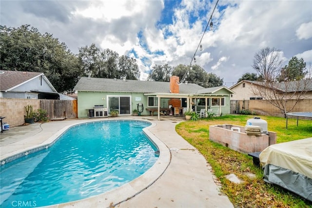 view of pool with a trampoline and a patio