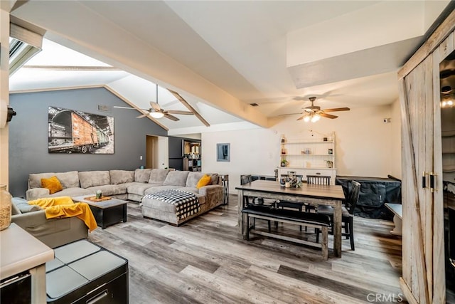 living room featuring ceiling fan, wood-type flooring, and vaulted ceiling with beams