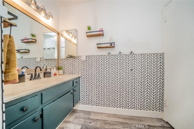 bathroom with hardwood / wood-style floors, vanity, and tile walls