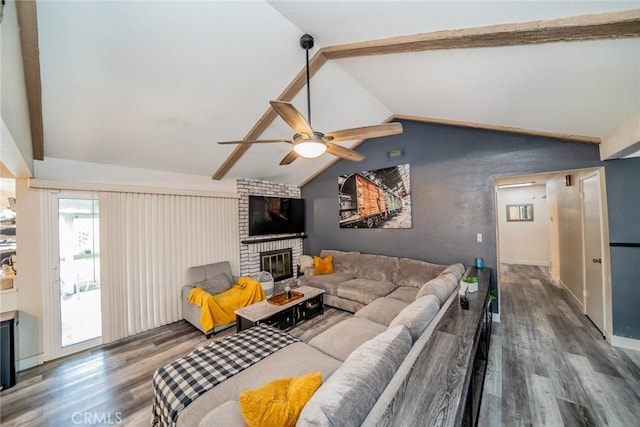 living room with ceiling fan, dark hardwood / wood-style floors, vaulted ceiling with beams, and a fireplace