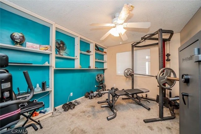 workout area featuring ceiling fan, carpet flooring, and a textured ceiling