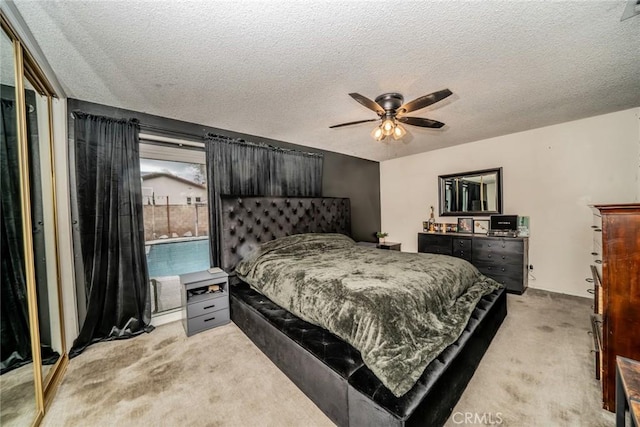 carpeted bedroom featuring a textured ceiling and ceiling fan