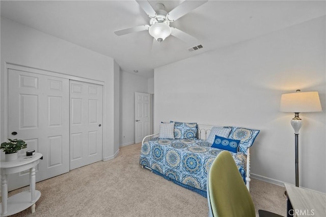 carpeted bedroom featuring ceiling fan and a closet