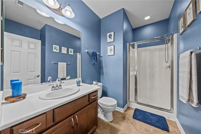 bathroom featuring tile patterned flooring, vanity, toilet, and a shower with shower door