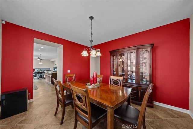 dining space featuring tile patterned floors and a chandelier