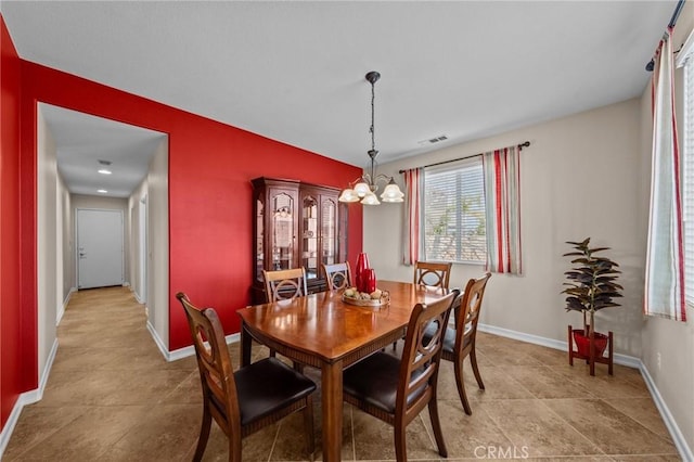 dining area featuring light tile patterned floors and a notable chandelier