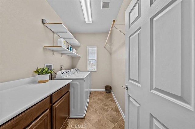 clothes washing area with cabinets and washer and dryer