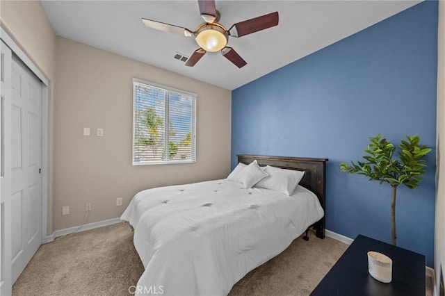 bedroom with ceiling fan, a closet, and light carpet