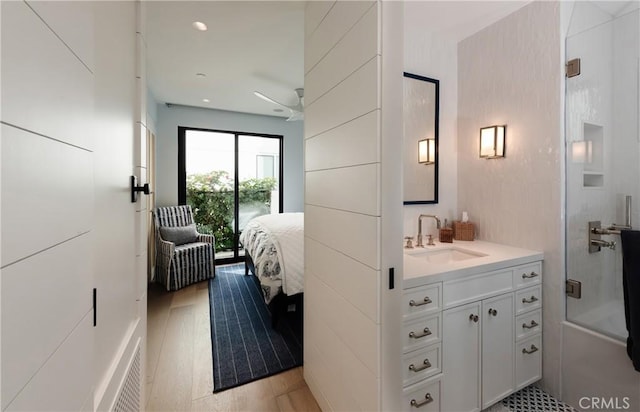 bathroom with hardwood / wood-style flooring, vanity, ceiling fan, and shower / bath combination with glass door