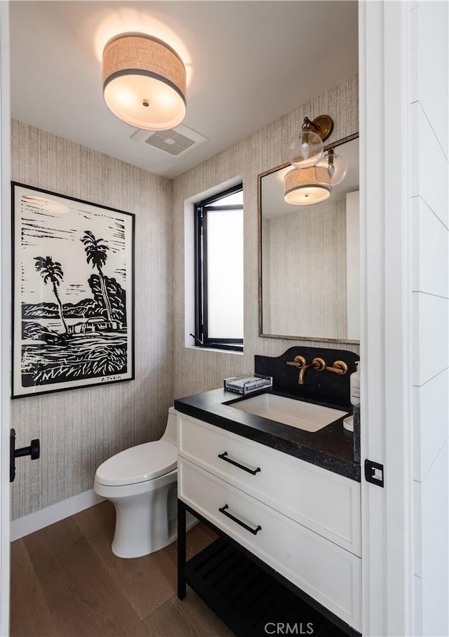 bathroom featuring vanity, hardwood / wood-style floors, and toilet