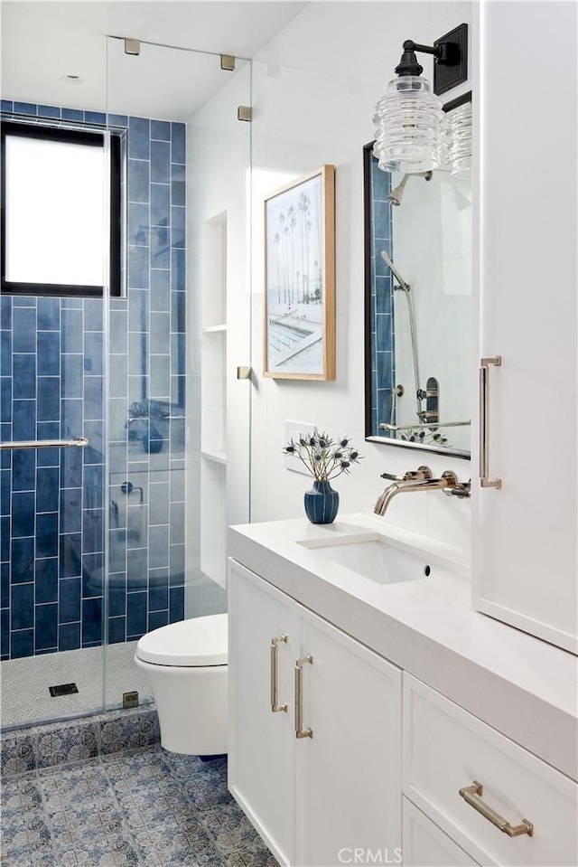 bathroom featuring vanity, toilet, and an enclosed shower