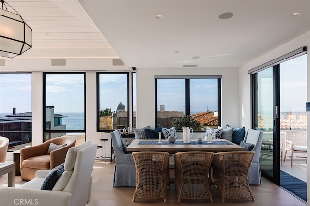 dining area with a water view and light wood-type flooring