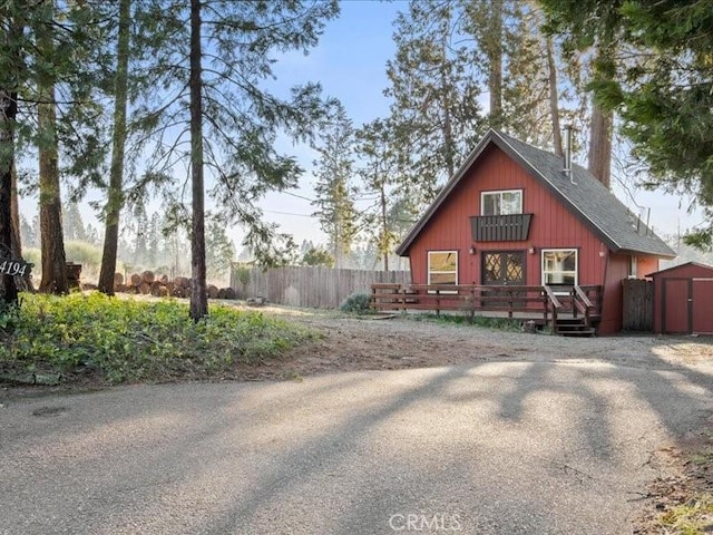 exterior space with a wooden deck and a storage unit