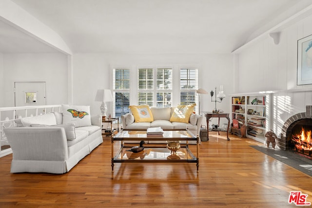 living room featuring lofted ceiling and hardwood / wood-style floors