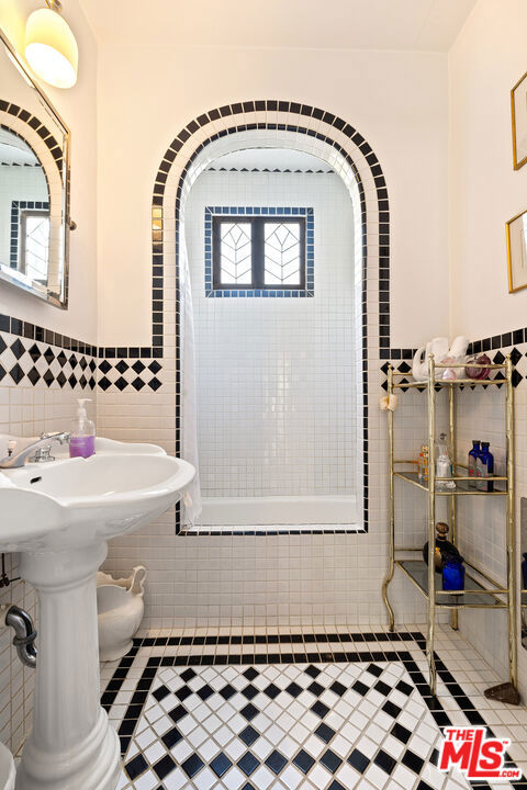 bathroom featuring tile patterned floors and tile walls