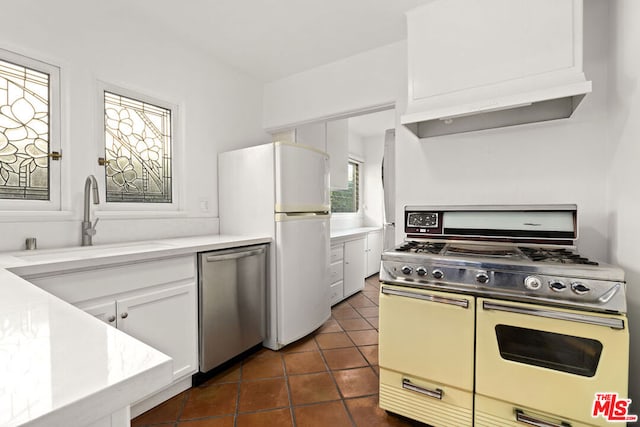 kitchen featuring sink, dishwasher, white cabinetry, double oven range, and white fridge