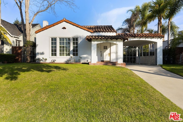 mediterranean / spanish-style home with a front yard and a carport