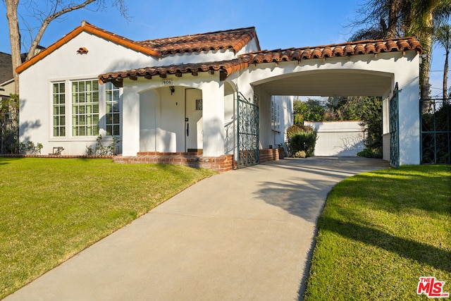 mediterranean / spanish-style house featuring a carport and a front yard