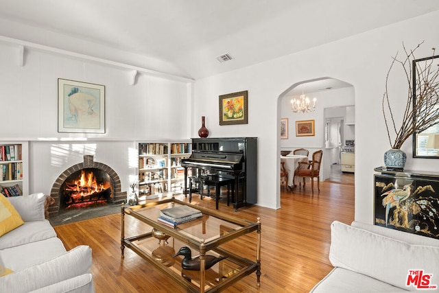 living room with a brick fireplace and hardwood / wood-style floors