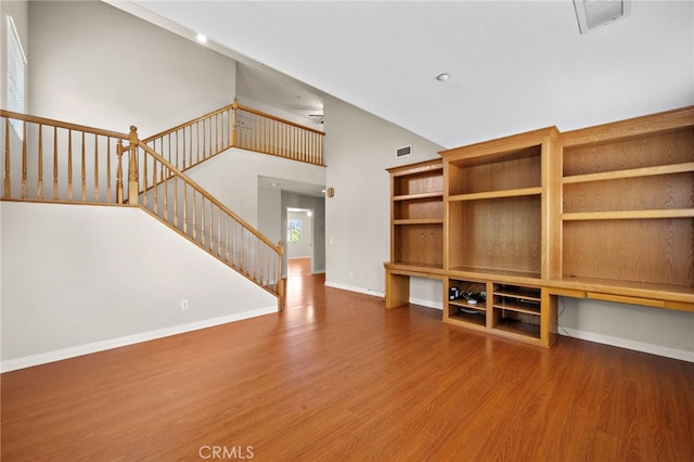 8015 Ralston Pl, Riverside, CA 92508 - unfurnished living room with wood finished floors, baseboards, stairs, and high vaulted ceiling