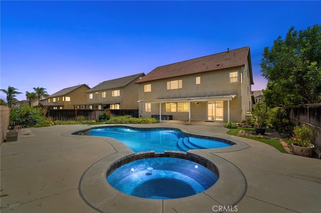8015 Ralston Pl, Riverside, CA 92508 - pool at dusk featuring a patio area, a pool with connected hot tub, and a fenced backyard