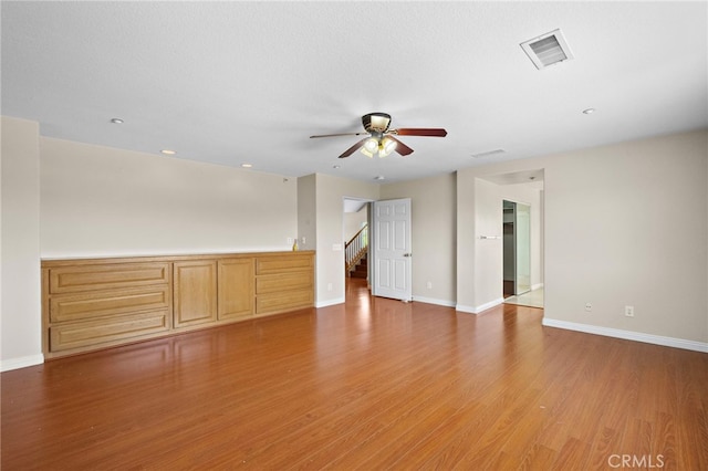 8015 Ralston Pl, Riverside, CA 92508 - unfurnished living room featuring ceiling fan, baseboards, light wood finished floors, and stairway