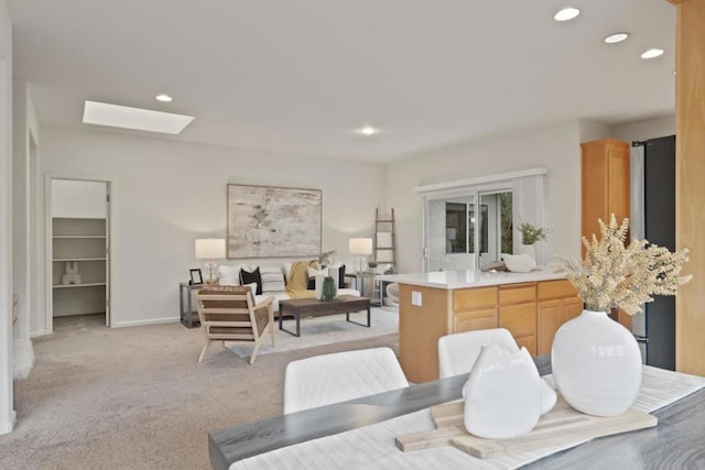 carpeted dining room with a skylight