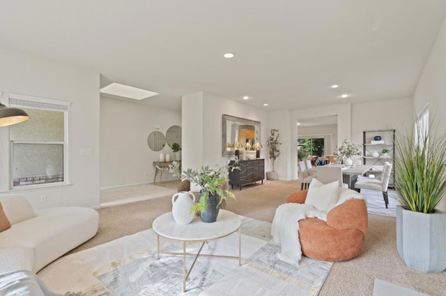 carpeted living room with a skylight