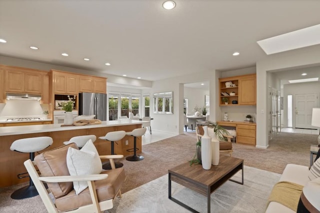 carpeted living room with a skylight