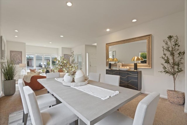 dining area featuring light carpet