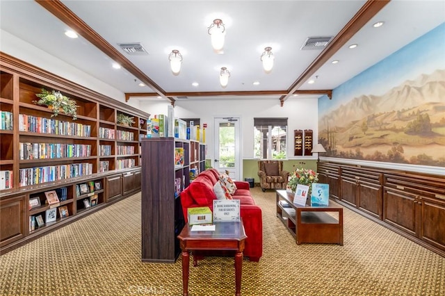 sitting room featuring beamed ceiling and light carpet