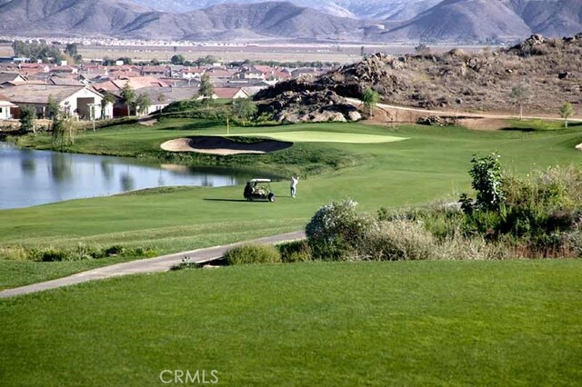 view of community featuring a water and mountain view and a lawn