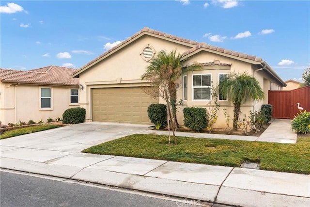 view of front of home with fence, a tile roof, concrete driveway, stucco siding, and an attached garage