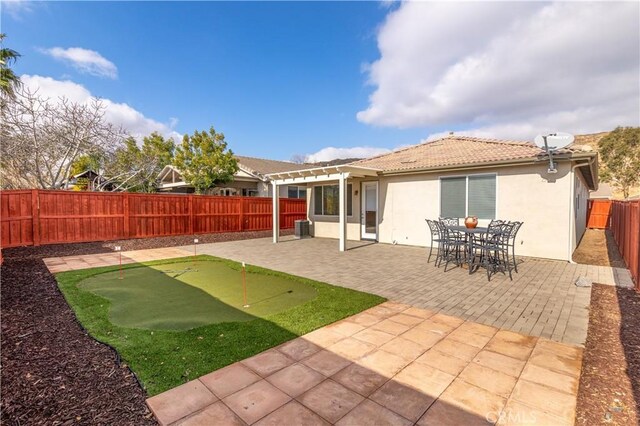 back of property with central AC unit, a pergola, and a patio