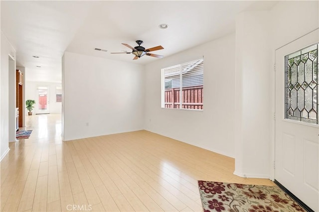 empty room with ceiling fan and light hardwood / wood-style flooring