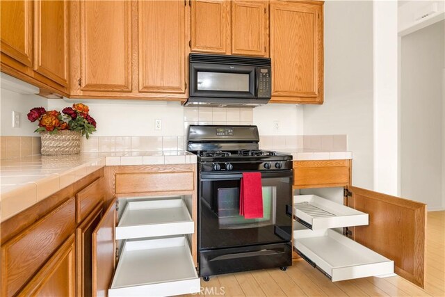 kitchen featuring tile counters and black appliances