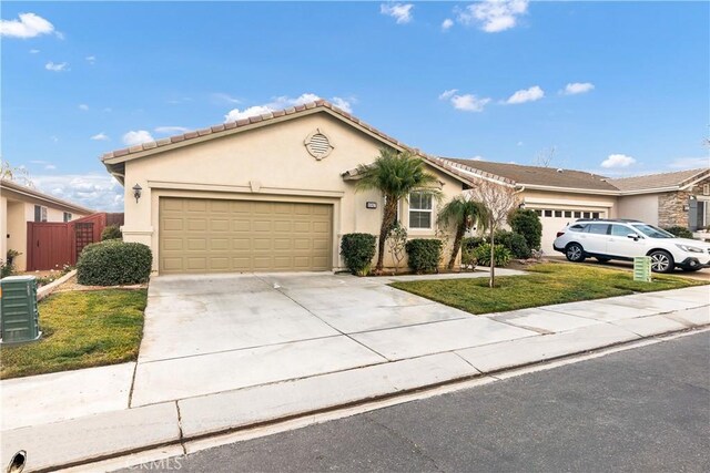 view of front of house featuring cooling unit, a garage, and a front yard