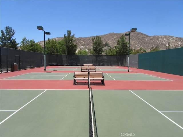 view of sport court with basketball hoop and a mountain view