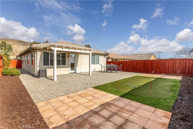 rear view of property with a pergola, central AC unit, and a patio area