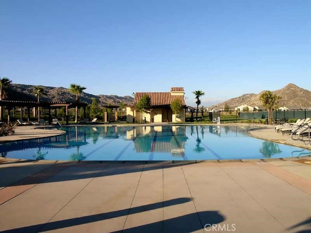 view of swimming pool featuring a patio and a mountain view