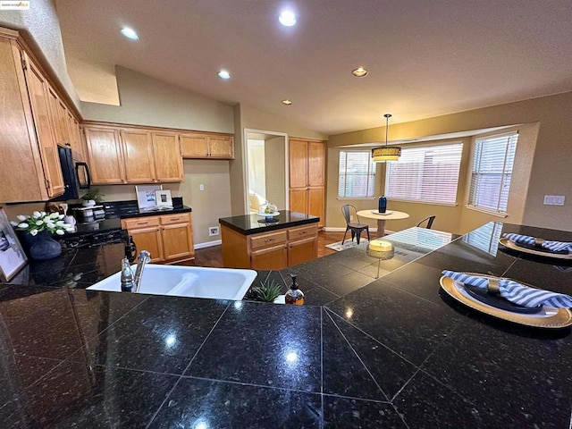 kitchen featuring lofted ceiling, sink, stainless steel range with gas stovetop, a kitchen island, and decorative light fixtures