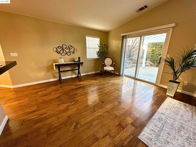 interior space featuring hardwood / wood-style floors, vaulted ceiling, and a wealth of natural light