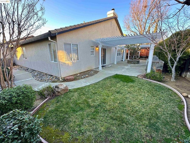 back of property featuring a yard, a pergola, and a patio