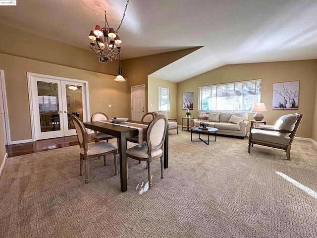 dining area with lofted ceiling, carpet floors, french doors, and an inviting chandelier