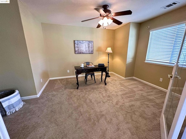 carpeted office space with ceiling fan