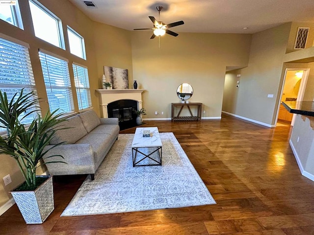 living room featuring a towering ceiling, dark hardwood / wood-style floors, and ceiling fan