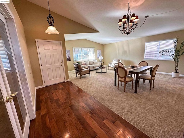 dining space featuring vaulted ceiling, dark hardwood / wood-style floors, a wealth of natural light, and an inviting chandelier